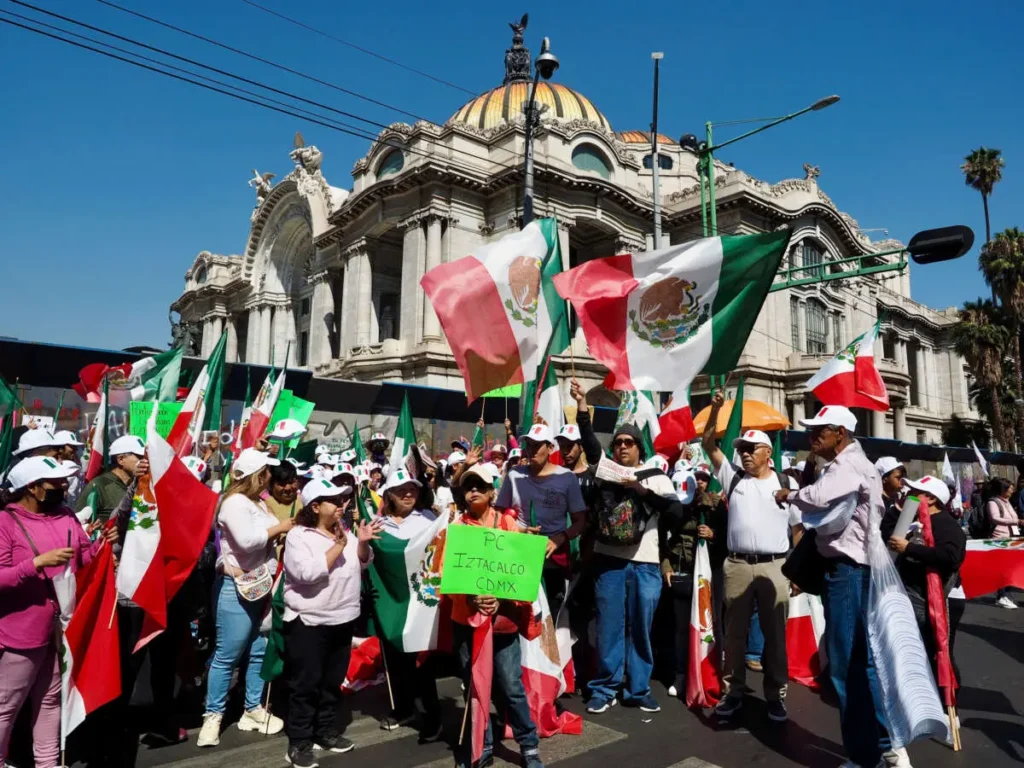 Demonstrators pose while waving the Mexican flags in front of the Palace of Fine Arts in Mexico City on Sunday, March 9, 2025. Photo: José Luis Granados Ceja