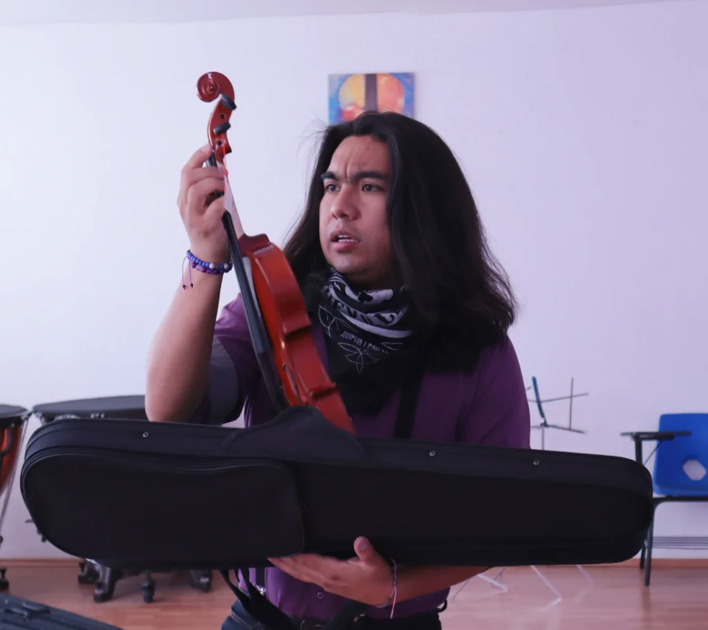 Abraham Hernández taking inventory of instruments in a classroom of a School for Life where he teaches music. Photo: Hans Leguízamo, 2025.